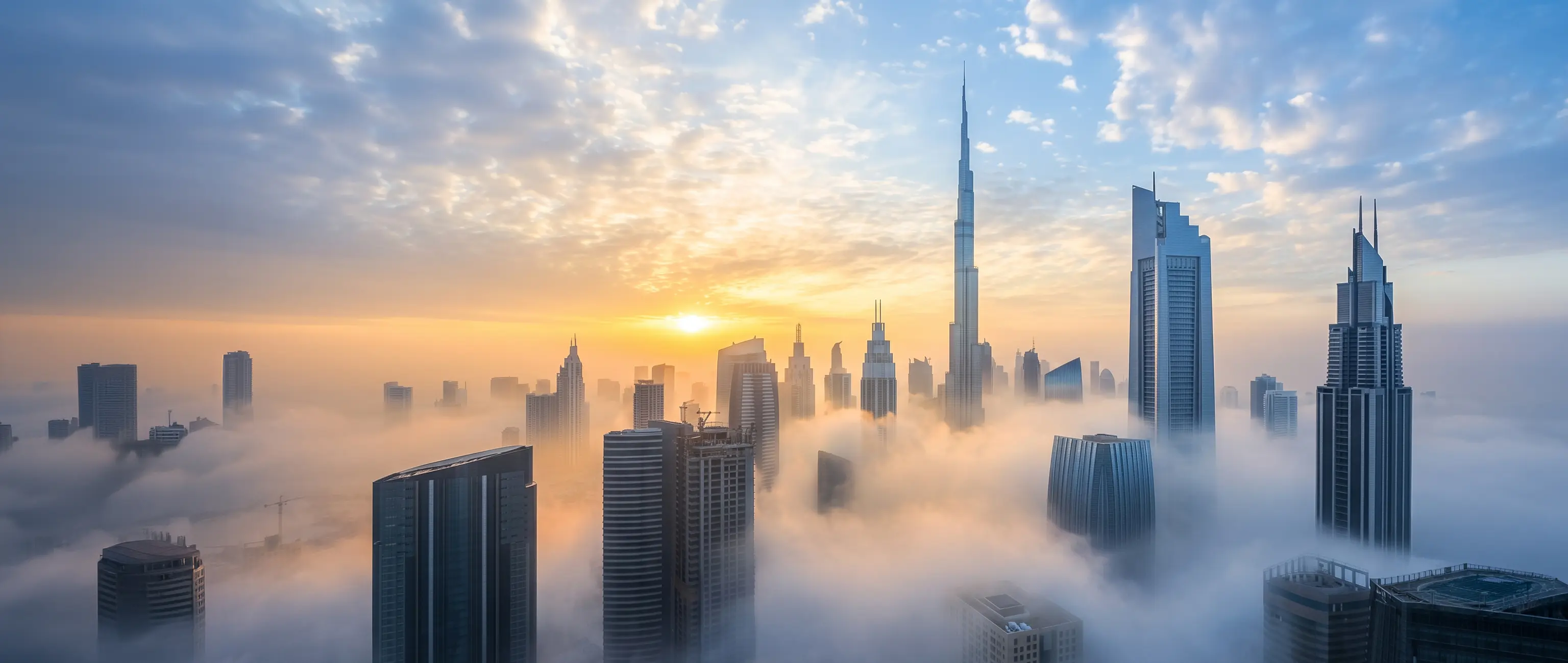 A breathtaking sunrise over the Dubai skyline rising above the clouds, symbolizing the clear vision, bright future, and strong UAE heritage you discover when you get to know National Bonds.